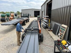 Workers assembling metal roofing materials.